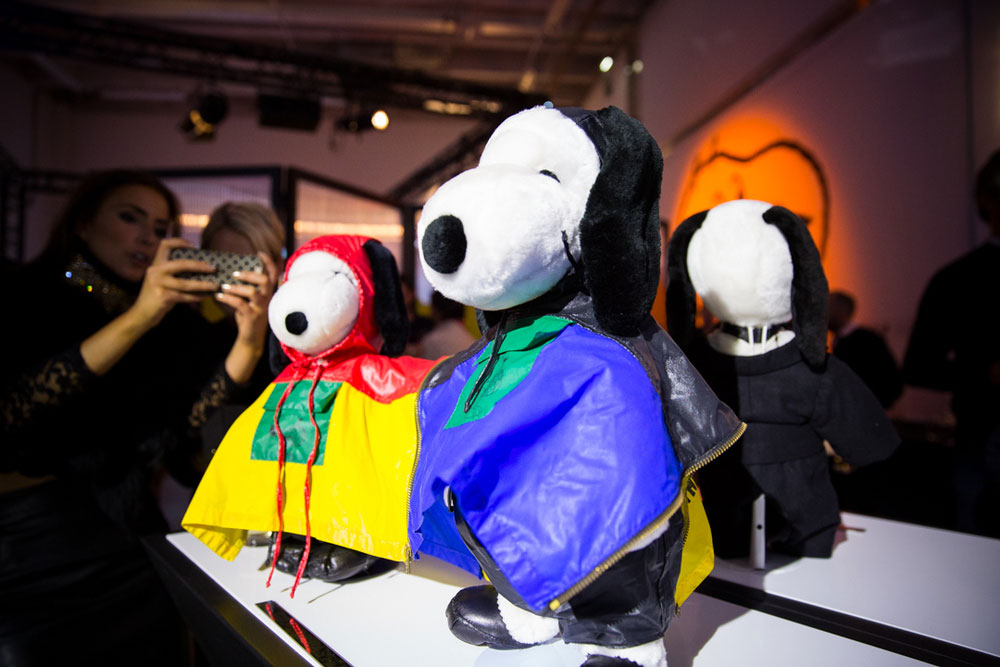 A close-up of black and white dog statues on display, wearing colourful raincoats.