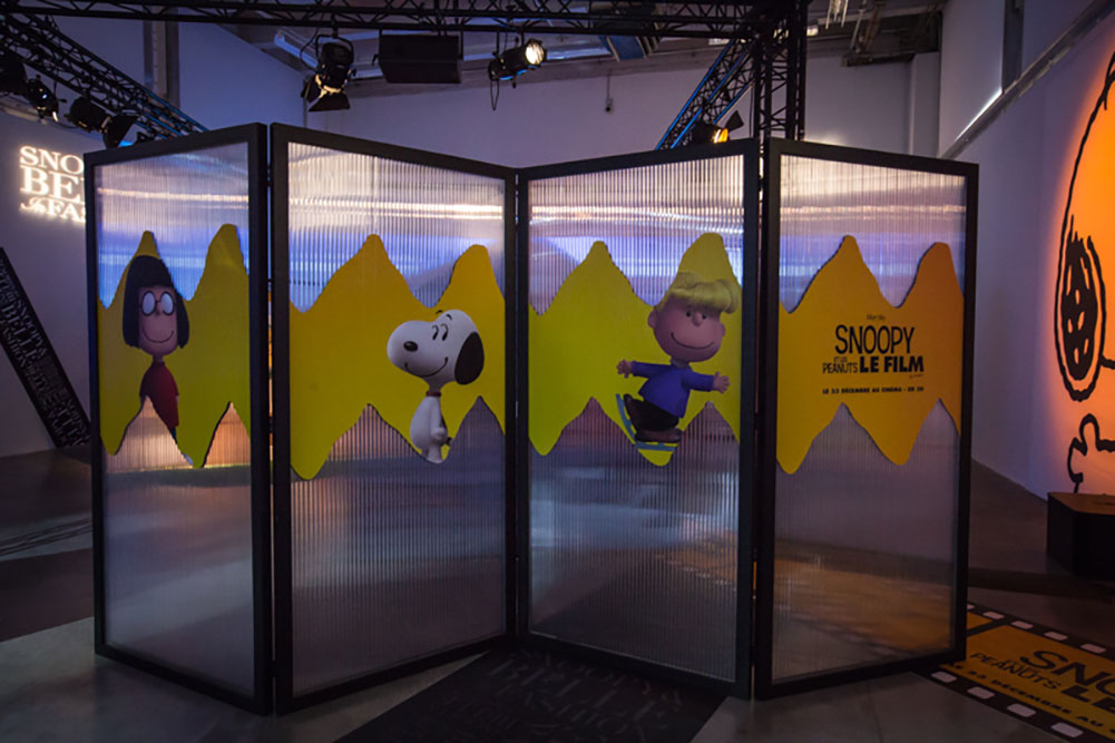 An indoor space with a large glass divider in the middle of it. The divider has cartoon character illustrations on it.