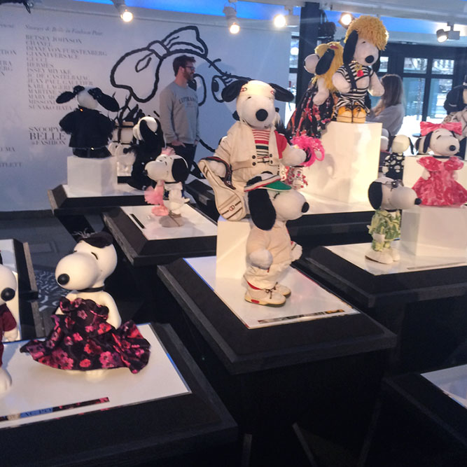 A close-up of black and white dog statues on display, dressed in designer costumes, at an indoor event.