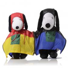 Two black and white dogs in front of a white background. The dog on the left is wearing a red and yellow rain poncho. The dog on the right is wearing a black and purple poncho.