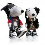 Two black and white dogs in front of a white background. The dog on the left is wearing a grey hat, headphones, red shirt and converse sneakers. The dog on the right is wearing a cheetah print dress, converse shoes and a black vest.