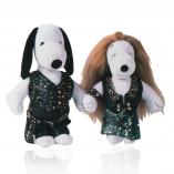 Two black and white dogs in front of a white background wearing black and blue sparkly outfits.