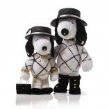Two black and white dog statues in front of a white background. They are wearing black hats, black shoes and white tops with black detailing.