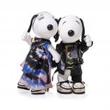 Two black and white dog statues in front of a white background. The dog on the left is wearing a tie dye dress and the dog on the right is wearing a tie dye shirt, leather jacket and black pants.