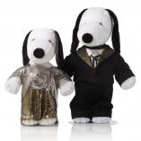 Two black and white dog statues in front of a white background. The dog on the left is wearing a gold and silver, sparkly dress. The dog on the right is wearing a black suit.