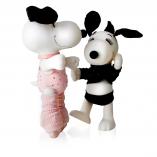 Two black and white dog statues in front of a white background. The dog on the left is on her tippy toes and wearing pink ballet slippers with a pink bodysuit. The dog on the right is wearing black shorts and t-shirt.