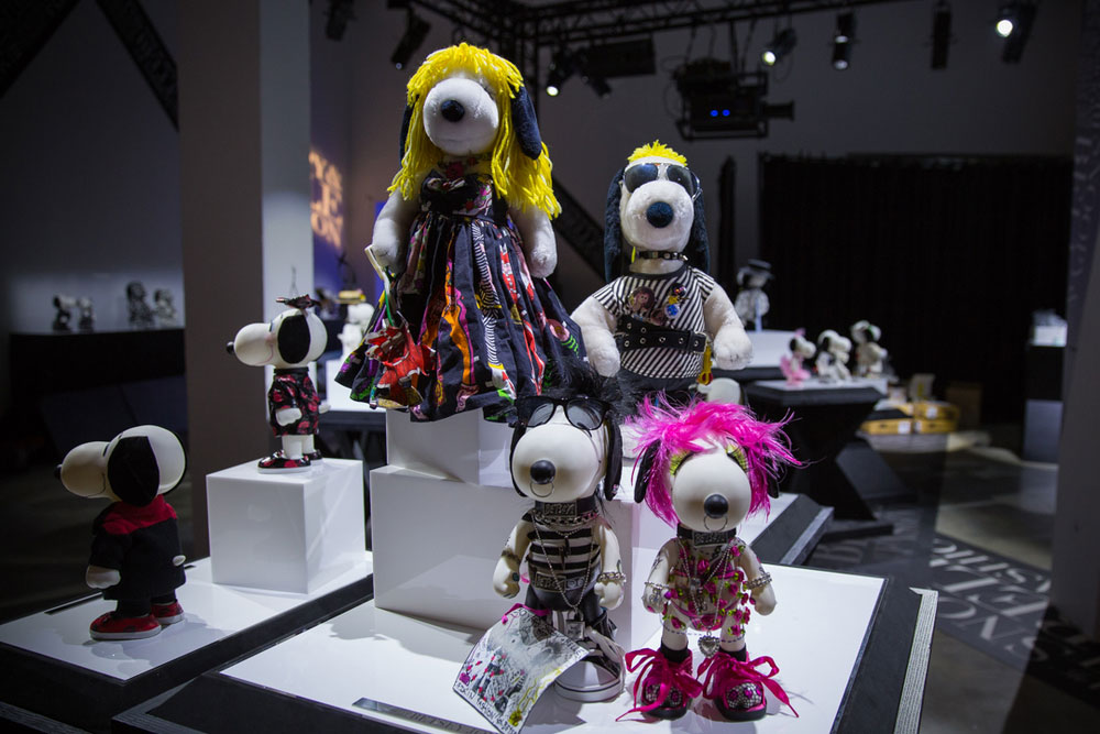 Black and white dog statues, wearing various costumes, on display in an indoor space.