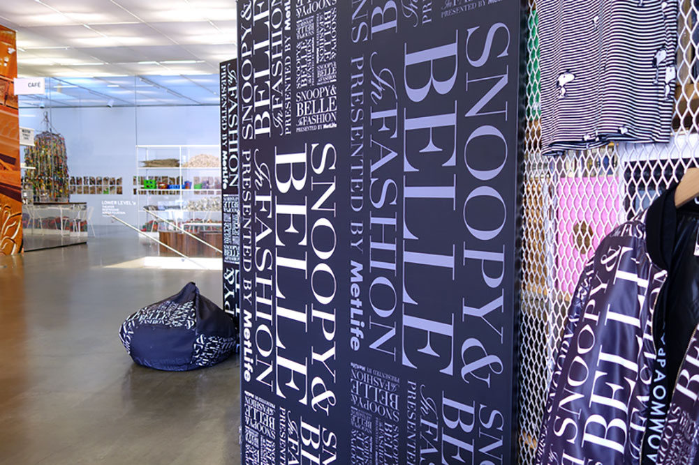 A bright indoor space selling various merchandise. There is a large black wall on the right side with white text.