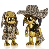 Two gold dog statues in front of a white background.