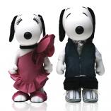 Two black and white dog statues in front of a white background. The dog on the left is wearing a magenta dress and the dog on the right is wearing a black vest and black pants.