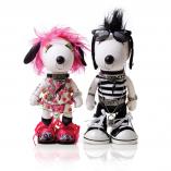 Two black and white dog statues in front of a white background. The dog on the left is wearing a pink wig, a pink dress and black and pin shoes. The dog on the right is wearing a black and white striped outfit.