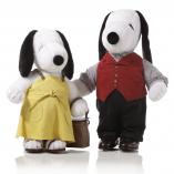 Two black and white dog statues in front of a white background. The dog on the left is wearing a yellow dress and the dog on the right is wearing black pants and a red vest.