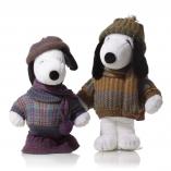 Two black and white dog statues in front of a white background wearing wool sweaters.