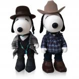 Two black and white dog statues in front of a white background wearing cowboy and cowgirl outfits.